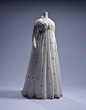 约1795，意大利。从优雅的丝绸长裙到朴素的棉布裙，1798年的法国大革命为服饰领域也带来了一个大转折。19世纪初，白色平纹细布裙席卷了欧洲。这种裙子有着极高的胸线，之下是散开的一片式裙体。大革命前玛丽·安东涅特曾穿着类似款式，她一度躲避宫廷生活穿着简约棉布长裙，戴着草帽，住在小提亚侬宫。