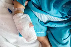 儿童疾病。小婴儿在病床上给病人的手上接上静脉导管。宝宝病了，趴在妈妈身上哭