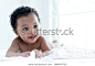 Dark-skinned baby boy laughed happily on the bed