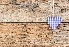 蓝色的心织物挂在复古的木板上