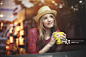 Girl drinking coffee in cafe near window