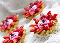 漂亮美味的纸杯蛋糕靠近草莓，金银花和粉红色奶油