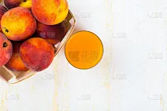 玻璃杯里有桃子汁和成熟的桃子
