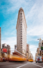 Blurred street view of traffic passing Flatiron Building.