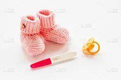 验孕棒和粉色女娃鞋。怀孕和怀孕观念
