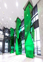 Vibrant green, mirrored, multi-faceted glass columns soar in this new condo lobby, designed by Munge Leung. The columns are a dynamic accent adding life and vibrancy to the clean, sophisticated, modern space. Eventscape engineered, fabricated and installe