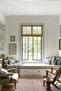 Mixed-width boards in the flooring, walls, and ceiling make for a relaxed sitting area where the window seat is a focal point.