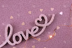 爱。桃红色背景上的爱字。情人节。浪漫的概念