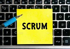 电脑键盘背景上的一张黄色贴纸上写着“SCRUM”。