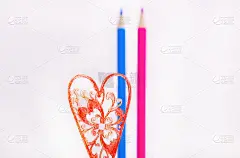 白色背景上的彩色铅笔。一对相爱的夫妇。蓝色和粉红色的铅笔。彩色铅笔和一颗红心