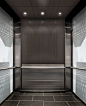 Glass walls with black and white photograph are the bright feature of this Elevator Interior Design: