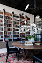Moderne Hausbibliothek runder Tisch Sitzgelegenheiten weiße orchideen passendes Licht