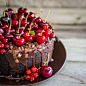 Chocolate cake with cherries on wooden background by Alena Haurylik on 500px