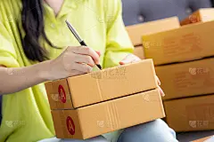 特写手的年轻亚洲妇女写地址在包裹盒子在家里为客户交付订单，航运和物流，网上和卖家，企业主或中小企业，