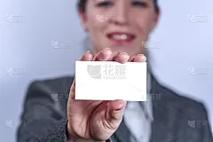 身着灰色西装的年轻女子拿着名片