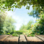 empty wooden table top on blur abstract green garden from window summer morning view with blue sky and green leaves