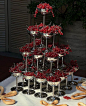 a table topped with lots of silver cups filled with cherries