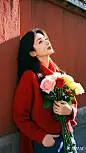 红墙，现代美女，两只手插在衣服口袋里。斜靠在红墙上， 平视，带个红围巾，穿着红色毛衣。抱着一大束彩色玫瑰花，丁达尔效应，阳光洒落，光影变化 ...