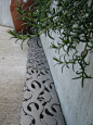 Could have similar inset stainless steel coverings along the perimeter of the garden wall.: 
