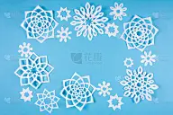 蓝色背景上的纸雪花。前视图。圣诞装饰