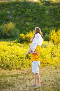 父亲扶着小女孩的肩膀，望着远方。