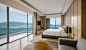 Corner suite with ocean-view floor-to-ceiling windows, platform bed and separate sitting area