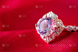 珠宝豪华粉金戒指与蓝宝石宝石在红色织物纹理的背景