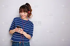 快乐的年轻女子听音乐耳机和手机
