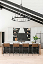 Photo of a large farmhouse single-wall kitchen in Charleston with a submerged sink, white cabinets, black splashback, stainless steel appliances, light hardwood flooring, an island, brown floors, white worktops and a vaulted ceiling.