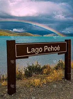 彩虹在木标志的名字“Lago Pehoe”，站在巴塔哥尼亚湖碧绿的水附近。托雷斯潘恩，巴塔哥尼亚，安