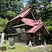 This may contain: a small wooden building with a red roof in the middle of some trees and grass