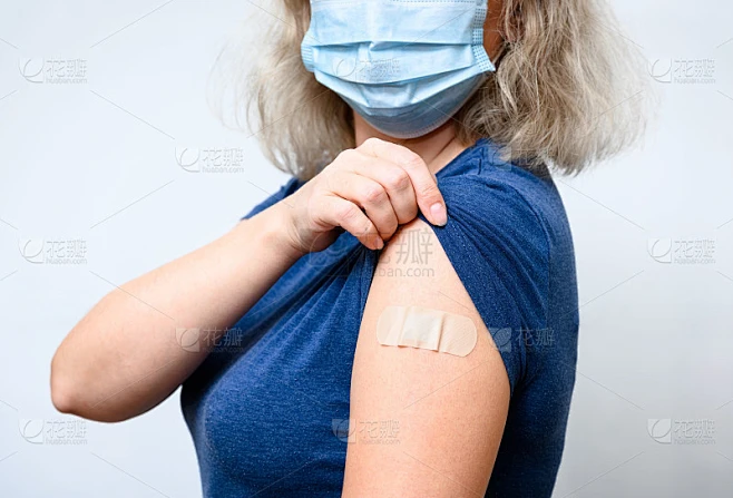 打过疫苗的年轻妇女用石膏露出肩膀