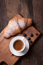 Croissant with coffee and blackberries on a wooden board. Selective focus - stock photo