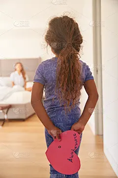 西班牙女孩在卧室里用自制的母亲节卡片给母亲惊喜