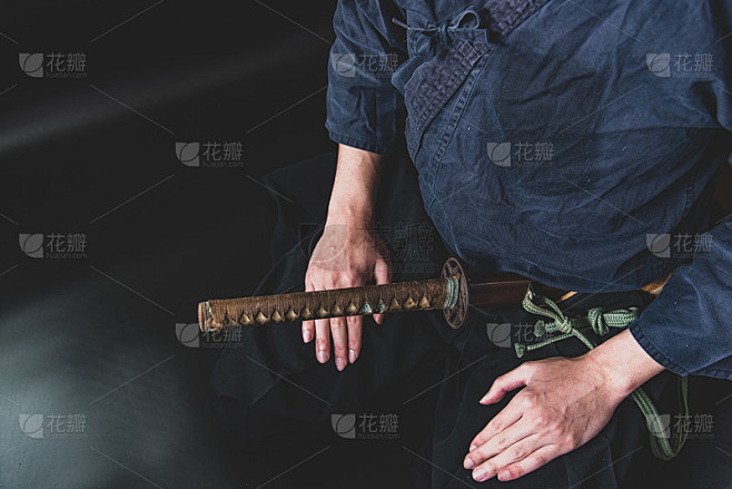一个坐着的人，一只手握着剑。