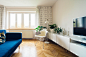 Living room in modern house with blue couch, white chair and flat-screen TV