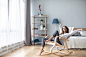 happy_woman_resting_comfortably_sitting_on_modern_chair_in_the_living_room_at_home