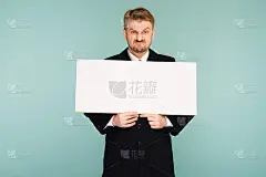 愤怒的胡子年轻的商人展示空白招牌