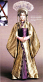 #星球大战服装# 系列（22）——前传三登基的纳布女王阿佩拉娜（Queen Apailana），出现在帕德梅的葬礼上。她的装束和帕德梅的和风造型很相似，但礼服是用亮银色和深紫色的丝绸制成，边缘绣着王室徽标，扇形头饰则是灰色羽毛和银制，更加华丽闪耀。她的面妆为蓝色，形如两行泪水，预示着黑暗时代的到来。除蓝色面妆外她的眼角贴着两粒钻石，使她显出一种哭泣中的悲哀表情。虽然这套服装非常华美，但较之帕德梅的相近款却缺乏一种平和的气质，令人不安。小女王后来因为暗中帮助抵抗军被察觉此事的西斯大帝派人杀害，只活了14岁。