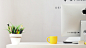 yellow ceramic mug beside gray aluminum iMac
