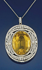 Circa 1905 diamond and citrine diamond pendant   The oval citrine within a diamond openwork panel with palmette decoration and old-cut diamond collet detail, to a fine link chain.