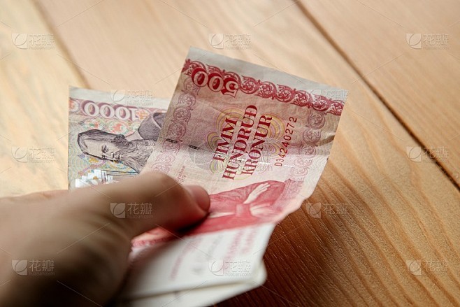 手持冰岛克朗银行券(现金)。