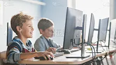 小学计算机科学课堂:聪明的小男孩在个人电脑上工作，学习软件编程语言。小学生接受现代教育。