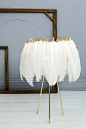 Feather Table Lamp White. These glamorous feather lamps feature luxurious black or white feathers held in place by a gold metal wire frame. Soft and delicate, the lights are reminiscent of the elegant feather boas and decadent hats of days gone by, but th