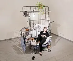 设计师用铁丝搭建了一个牢笼般的椅子家具，非常的具有开放性。随意舒适的毯子就是沙发垫和靠背了，很居家随性的感觉。最有意思的就是铁架子般的椅子主题结构，这些铁架子可以允许你去拓展它们，任何你想放的东西都可以放上去。就像一个大杂烩的柜子一样。是不是很适合你呢？