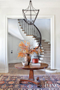 White and Brown Contemporary Entrance : Pure luxury is experienced upon entry when, once through the home’s massive African mahogany double doors, one is met with a double stairway that marks the centerpiece of the foyer.