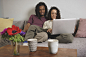 Young multi-ethnic couple using laptop while sitting on sofa at home by fStop_images on 500px