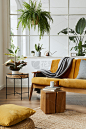 斯堪的纳维亚式的开放空间室内设计，黄色天鹅绒沙发、植物、家具、书籍、木质立方体和个人配件，时尚的家庭