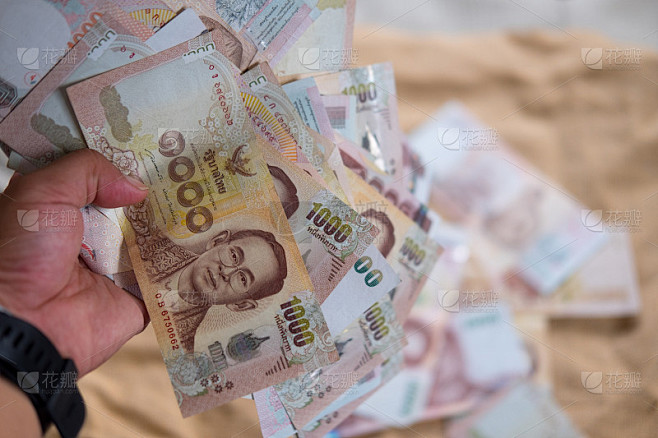 手里握着1000泰铢的泰国钱