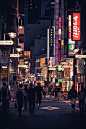 People Walking on the Street Between Buildings